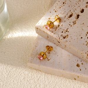 Close-up of pink round-cut gemstone stud earrings with 18k gold-plated four-prong setting
