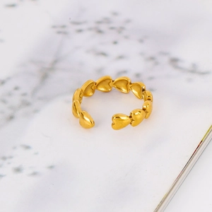 Detailed close-up of 18k gold heart-shaped ring with polished interconnected design