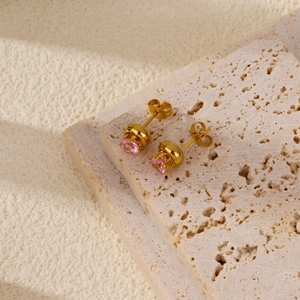 Detail of pink heart-shaped crystal earrings on stone texture background