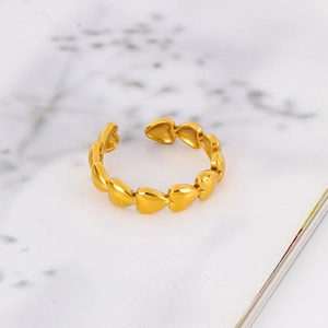 Detail showing polished 18k gold heart-shaped elements on the adjustable open ring
