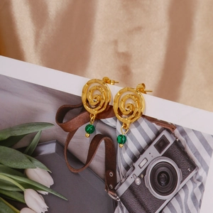 Detail of 18k gold stainless steel spiral earrings with a green malachite stone bead
