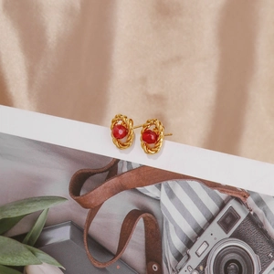 Detail of 18k gold vintage earrings with ruby red stone and twisted rope texture