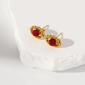 Detail shot of vintage 18k gold earrings with oval hollow design and ruby red stones