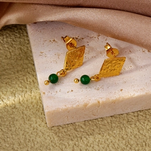 Orecchini a perla smeraldo stile francese con texture lava dorata su marmo