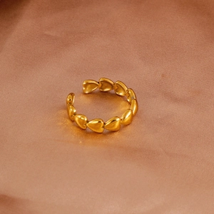 Detailed view of interconnected 18k gold heart rings on a silk satin background