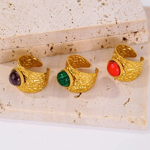 Detailed view of three vintage 18K gold textured open rings with colorful gemstones