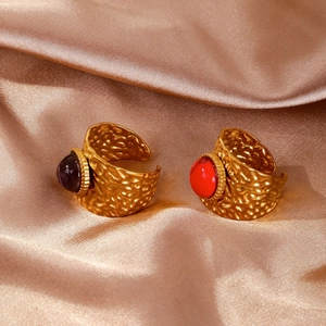 Detail of 18K gold hammered open rings featuring set purple and red oval gemstones