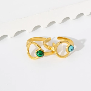 Detailed close-up of 18K gold open rings featuring green malachite and blue turquoise beads