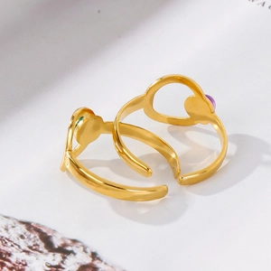 Detail shot of hollow 18K gold plated rings with purple and green enamel accents