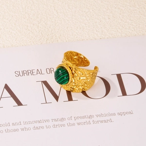 Macro detail of 18K gold hammered ring with turquoise stone inlay on a minimal backdrop