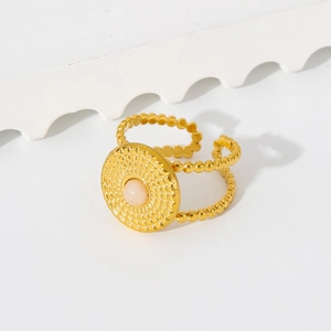 Macro view of a bohemian C-shape adjustable ring with pink gemstone and vintage gold beads