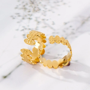 Detailed macro view of 18K gold adjustable rings with textured leaf relief patterns