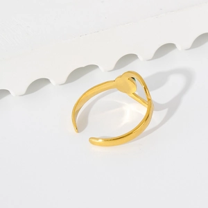 Detail shot of minimalist 18K gold open ring featuring a sleek disc and green accents