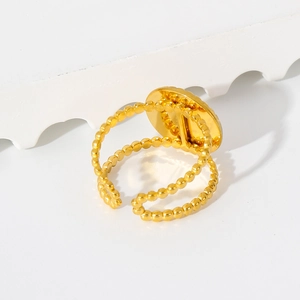 Close-up of golden double-layered beaded open ring with flat round metallic detail