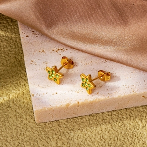 Exquisite goldene Stern-Ohrstecker mit grünen Zirkonia auf rosa Marmorstein