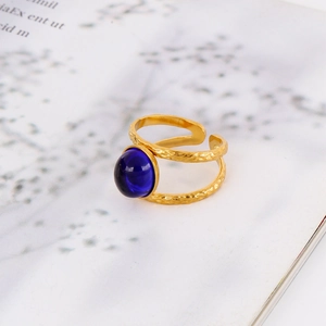Detail of 18k gold plated ring featuring blue gemstone and hammered texture band