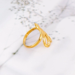 Detail of 18k gold plated stainless steel snake ring on marble background