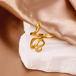 Minimalist 18k gold snake open ring displayed on stone with silk background texture