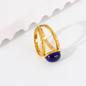 Detailed macro of 18k gold stainless steel ring with blue oval stone and hammered texture
