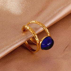 Macro detail of 18k gold plated hammered ring with a large oval deep blue gemstone