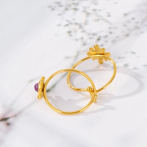Detail of 18K gold-plated open rings featuring natural purple stone and sunflower design