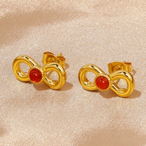Detailed close-up of 18k gold-plated stainless steel bow earrings with red ruby gemstones