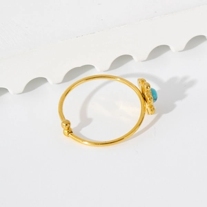 Macro shot of 18K gold sunflower ring featuring a round blue turquoise natural stone