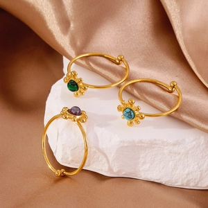 Three vintage 18K gold-plated open rings featuring natural stone inlays on stone podium