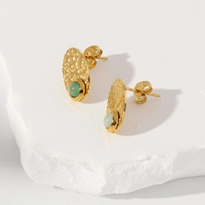 Detail of vintage lava texture gold earrings featuring inlaid green turquoise stones