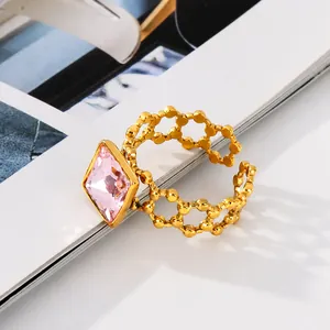 Detail of 18k gold hollow ring band with square pink zircon in open adjustable style
