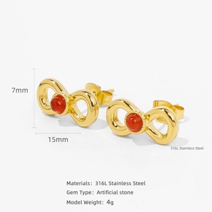 Detailed view of gold 316L stainless steel infinity earrings with red gemstones