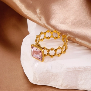 Detailed macro of 18k gold ring with square pink crystal and hollow geometric band