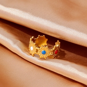 Detalle del anillo de margaritas en acero bañado en oro de 18k con esmalte sobre satén