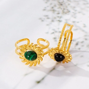 Detailed close-up of gold-plated sun flower rings with turquoise and black gemstones