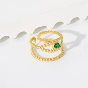 Close-up of gold-plated double-layer beaded ring with emerald green stone inlay