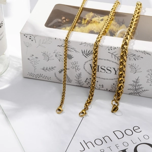 Detailed macro view of three golden spiga chains with lobster clasps on a white background