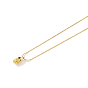 Détail d'un pendentif lingot d'or poli avec une chaîne serpent élégante en métal doré