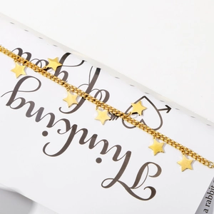Detail shot of golden star charm bracelet showing seven polished pentagrams on link chain