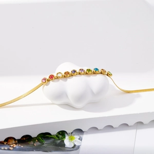 Detail of gold-plated snake chain necklace with colorful micro-pave cubic zirconia