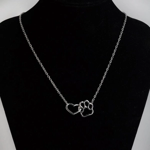 Minimalist silver heart and pet paw pendant necklace displayed on a black bust model