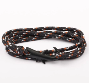 Dettaglio del bracciale in corda intrecciata nera e arancione con gancio a squalo opaco