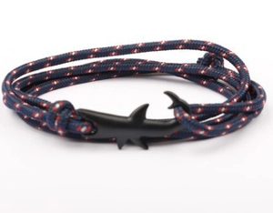 Dettaglio di un bracciale nautico in corda blu con chiusura a gancio a forma di squalo