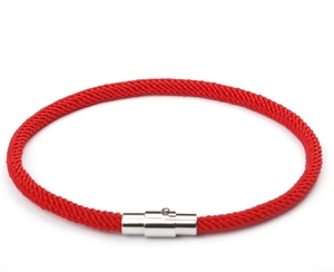 Detailed macro view of the red braided rope bracelet with silver magnetic cylinder clasp