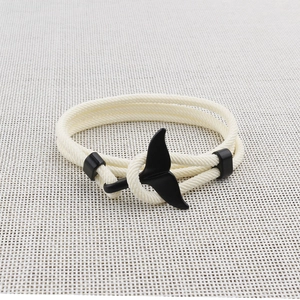 Dettaglio di un bracciale in corda intrecciata panna con gancio a coda di balena nero