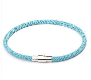 Macro view of light blue braided rope bracelet with polished silver magnetic clasp