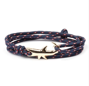 Dettaglio del bracciale in corda intrecciata blu navy con chiusura in metallo dorato a squalo