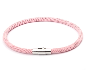 Close-up of pink woven rope bracelet featuring a polished silver metallic magnetic clasp
