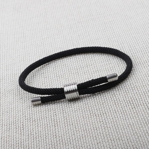 Detailed close-up of a black braided cord bracelet featuring adjustable silver metal sliders