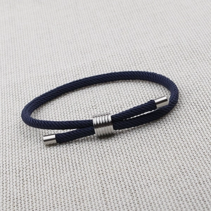Detail view of dark blue braided rope bracelet with adjustable silver metal slide clasp