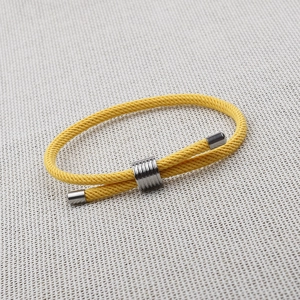 Close-up of bright yellow braided rope bracelet with adjustable silver metal slide clasp